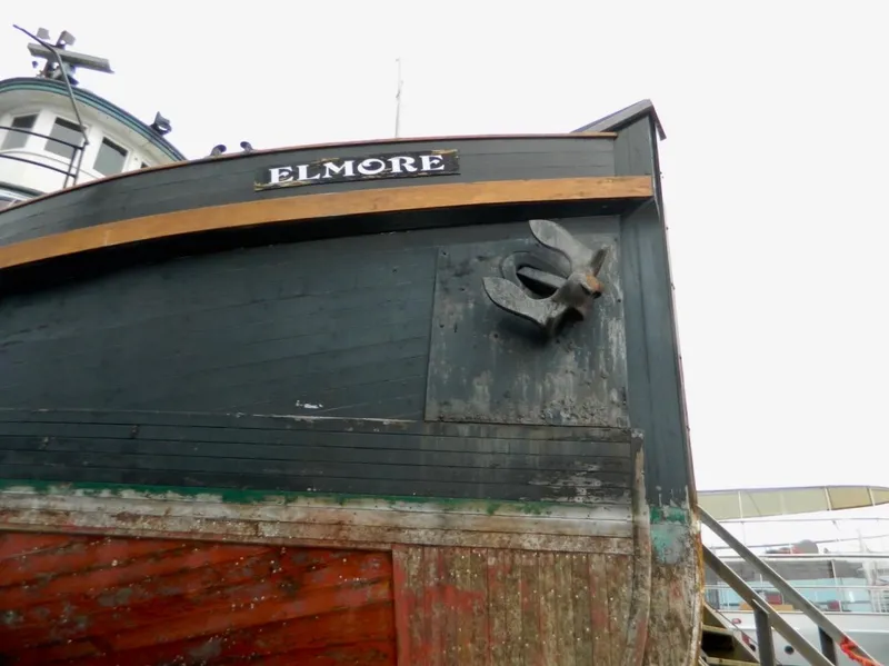 Slide: The Image of Historic 1890 custom tugboat "Elmore" with visible anchor and weathered hull. - 5