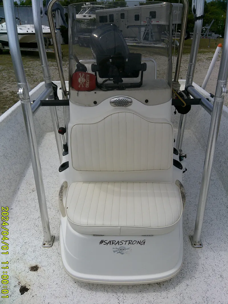 Slide: The Image of Mako 1901 boat console, 2008 model, with seating and steering wheel, parked outdoors. - 12