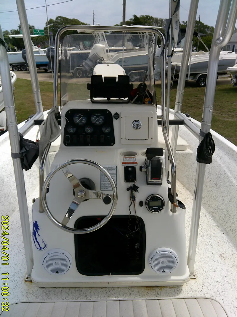 Slide: The Image of Center console of a 2008 Mako 1901 boat with steering wheel and gauges. - 18
