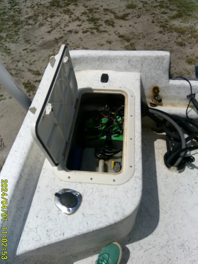 Slide: The Image of Open storage compartment on a 2008 Mako 1901 boat, showing internal wiring and equipment. - 23