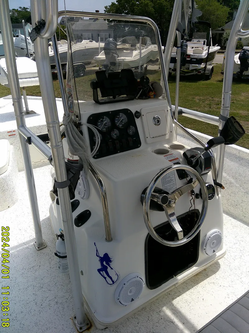 Slide: The Image of Center console of a 2008 Mako 1901 boat with steering wheel and gauges. - 24