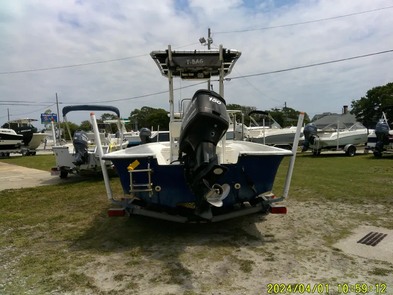 Slide: The Image of Mako 1901 boat, 2008 model, parked on grass with outboard motor, surrounded by other boats. - 6