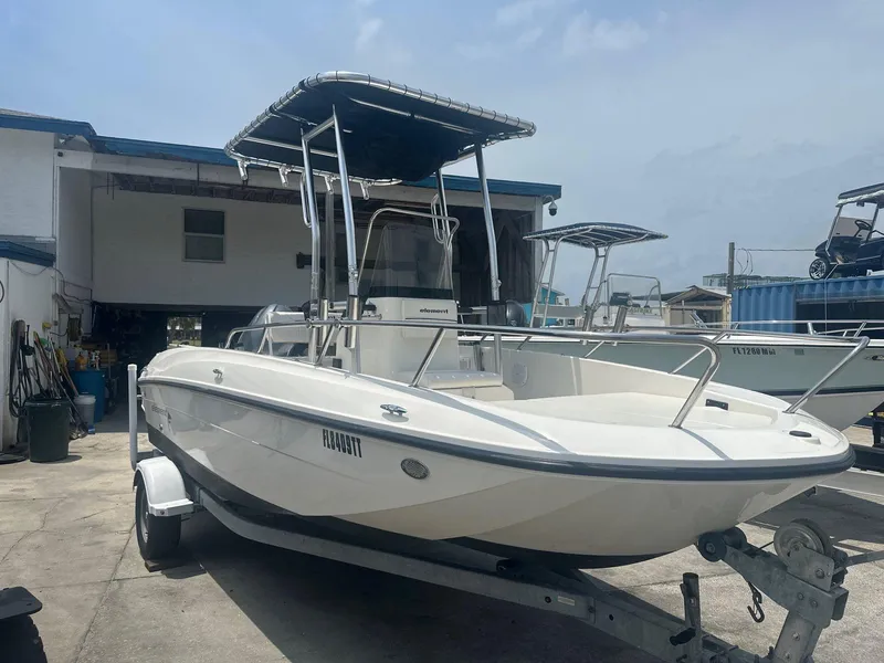Slide: The Image of 2016 Bayliner Element F18 boat on trailer, parked outdoors under a cloudy sky. - 1