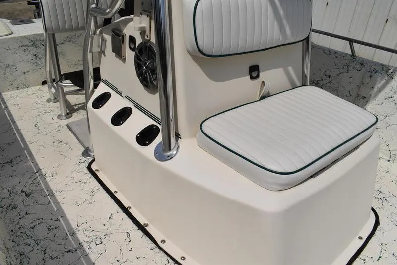 Slide: The Image of 1998 Kenner 21V CC Tunnel boat interior with white cushioned seating and control panel. - 21