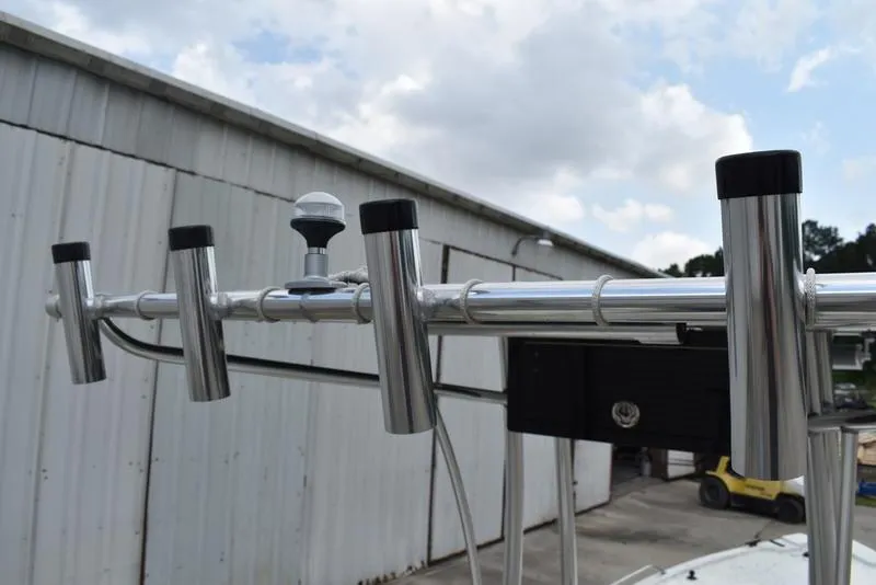 Slide: The Image of Rod holders on a 1998 Kenner 21V CC Tunnel boat against a cloudy sky. - 30