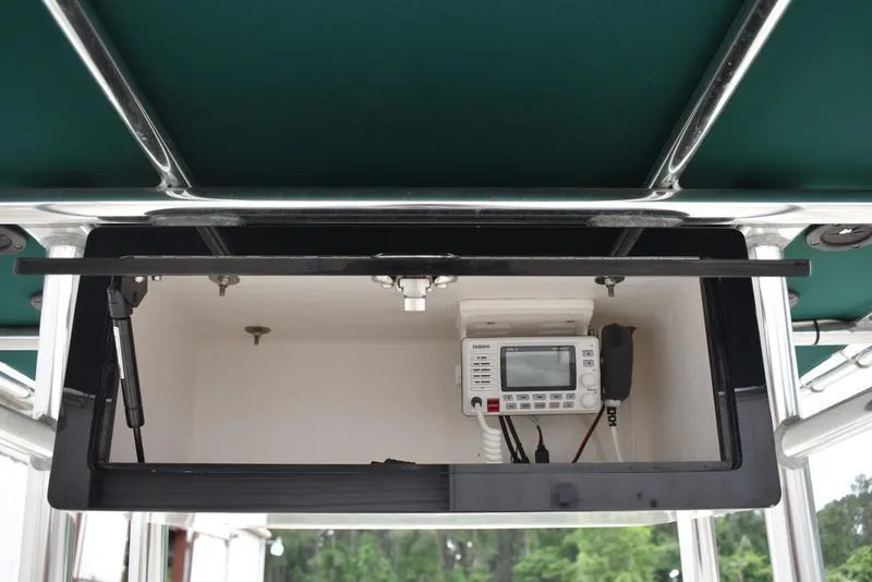 Slide: The Image of 1998 Kenner 21V CC Tunnel boat console with electronic equipment and green canopy. - 32