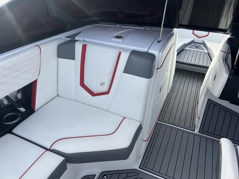 Slide: The Image of 2019 Nautique Super Air G23 interior with white and gray seating, red accents, and sleek flooring. - 2
