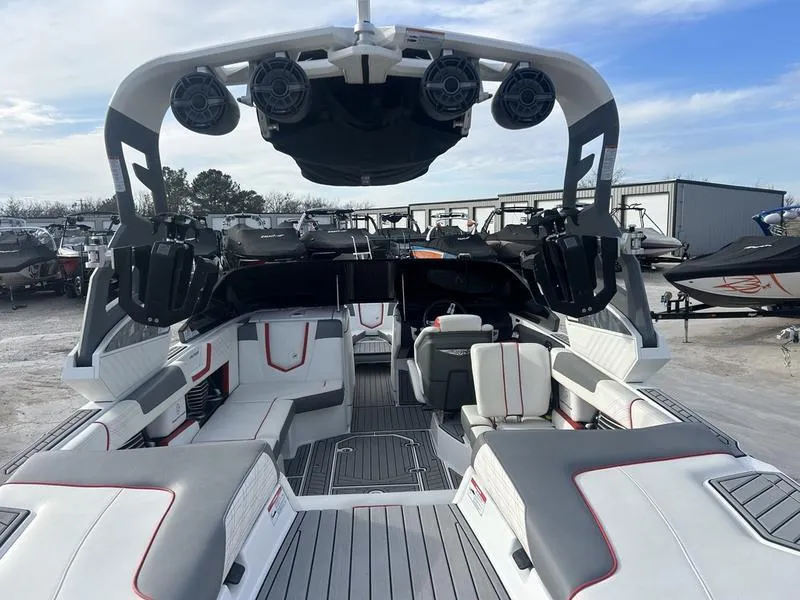 Slide: The Image of 2019 Nautique Super Air G23 boat interior with seating and speakers, docked outdoors. - 6