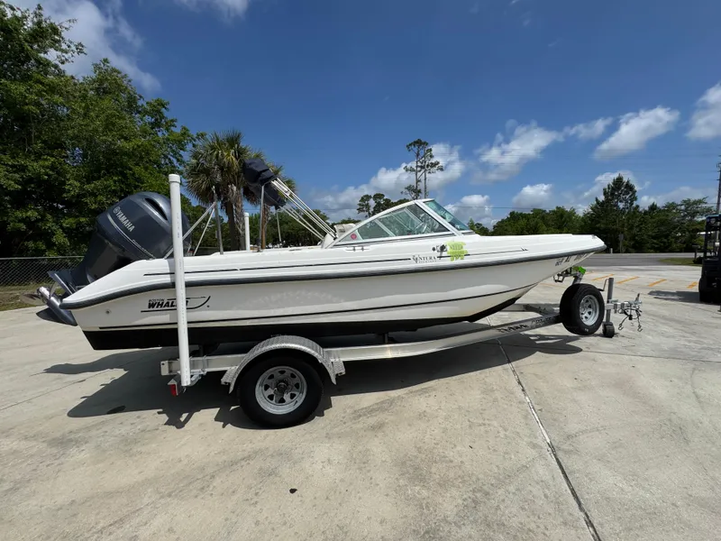 Slide: The Image of 2001 Boston Whaler 18 Ventura boat on trailer, parked outdoors under a clear blue sky. - 10