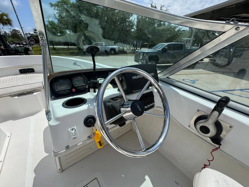 Slide: The Image of 2001 Boston Whaler 18 Ventura boat cockpit with steering wheel and control panel. - 21