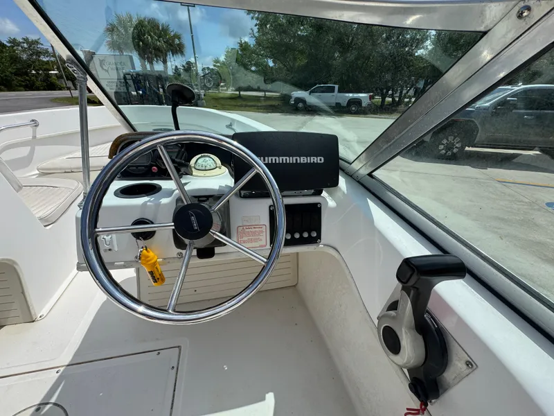 Slide: The Image of 2001 Boston Whaler 18 Ventura boat cockpit with steering wheel and Humminbird device. - 22