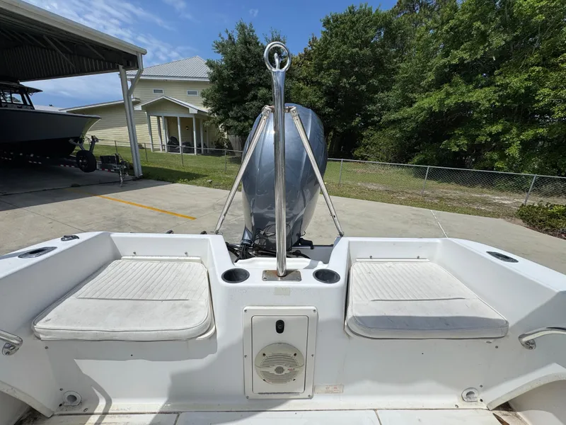 Slide: The Image of 2001 Boston Whaler 18 Ventura boat interior with seating and motor, parked outdoors. - 28