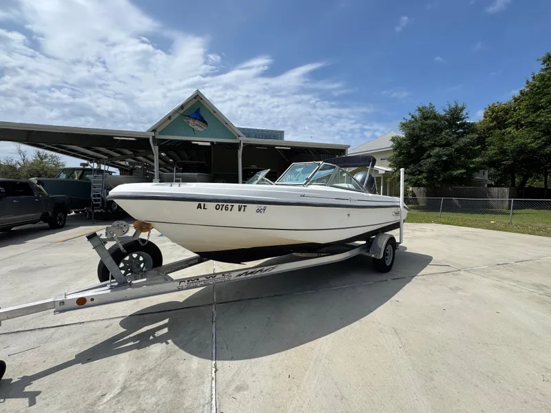 Slide: The Image of 2001 Boston Whaler 18 Ventura boat on trailer, parked outdoors under a partly cloudy sky. - 3