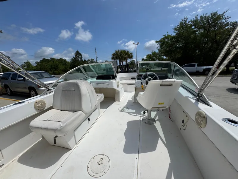 Slide: The Image of 2001 Boston Whaler 18 Ventura boat interior with seating and steering wheel under blue sky. - 31