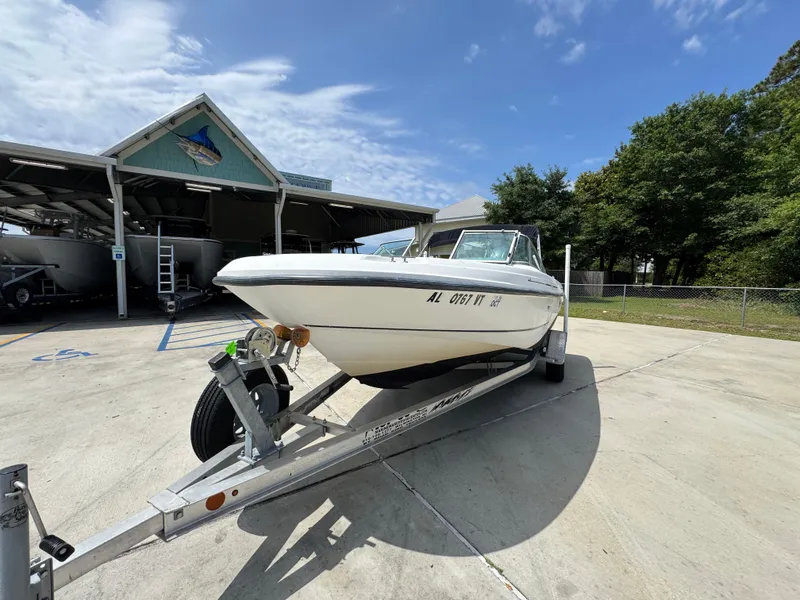 Slide: The Image of 2001 Boston Whaler 18 Ventura boat on trailer, parked outdoors under clear sky. - 4