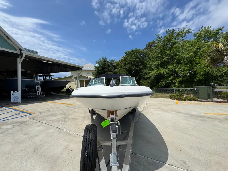Slide: The Image of 2001 Boston Whaler 18 Ventura boat on trailer, parked outdoors under a partly cloudy sky. - 6