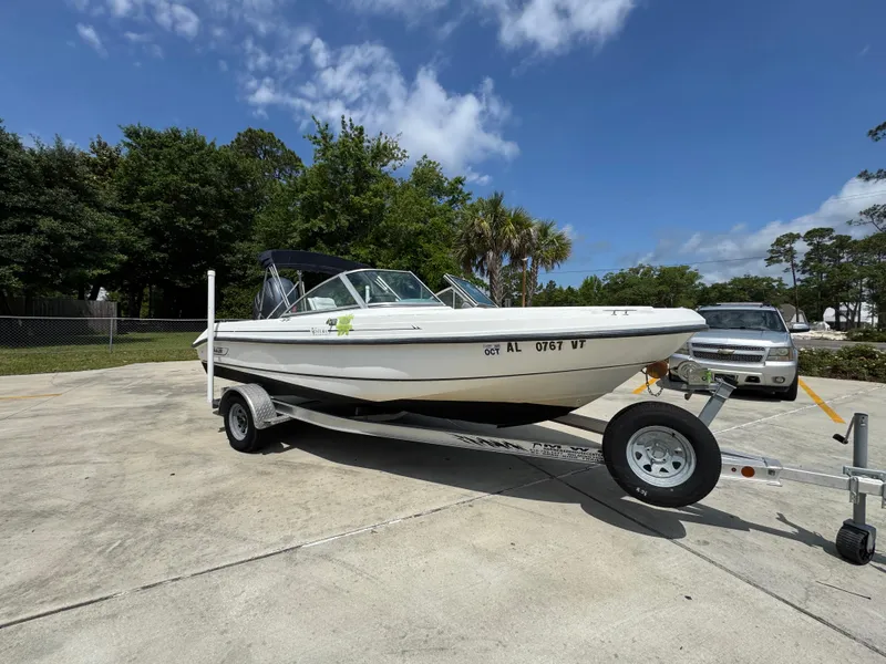 Slide: The Image of 2001 Boston Whaler 18 Ventura boat on trailer, parked outdoors under a clear sky. - 8