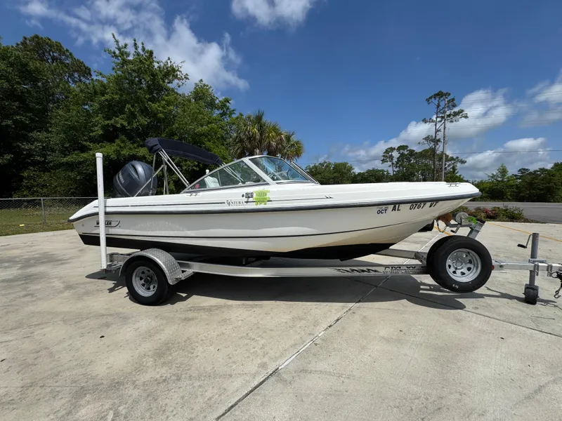 Slide: The Image of 2001 Boston Whaler 18 Ventura boat on trailer, parked outdoors under clear sky. - 9