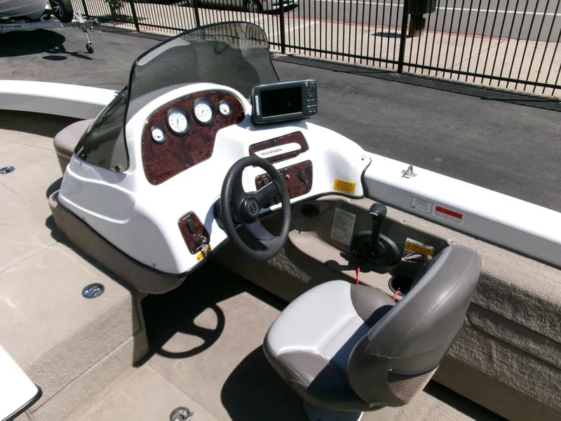 Slide: The Image of 2005 Tracker Tundra 18 DC boat dashboard with steering wheel and gauges. - 11