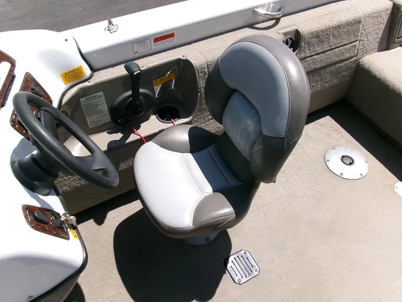 Slide: The Image of 2005 Tracker Tundra 18 DC boat interior with gray captain's chair and steering console. - 12