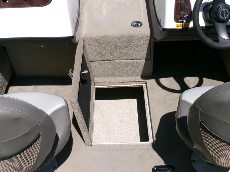 Slide: The Image of 2005 Tracker Tundra 18 DC boat interior with open storage compartment between seats. - 18