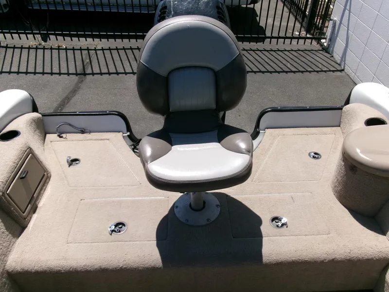 Slide: The Image of 2005 Tracker Tundra 18 DC boat seat on deck, beige upholstery, outdoor setting. - 25