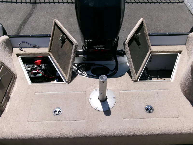 Slide: The Image of 2005 Tracker Tundra 18 DC boat interior with open storage compartments and motor. - 27
