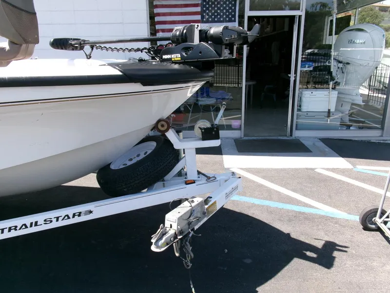 Slide: The Image of 2005 Tracker Tundra 18 DC boat on trailer, parked outside a store with American flag. - 29