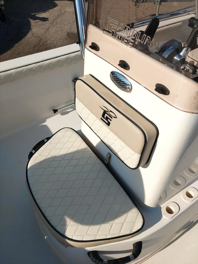 Slide: The Image of 2022 Carolina Skiff 19 LS boat interior with cushioned seating and steering console. - 4