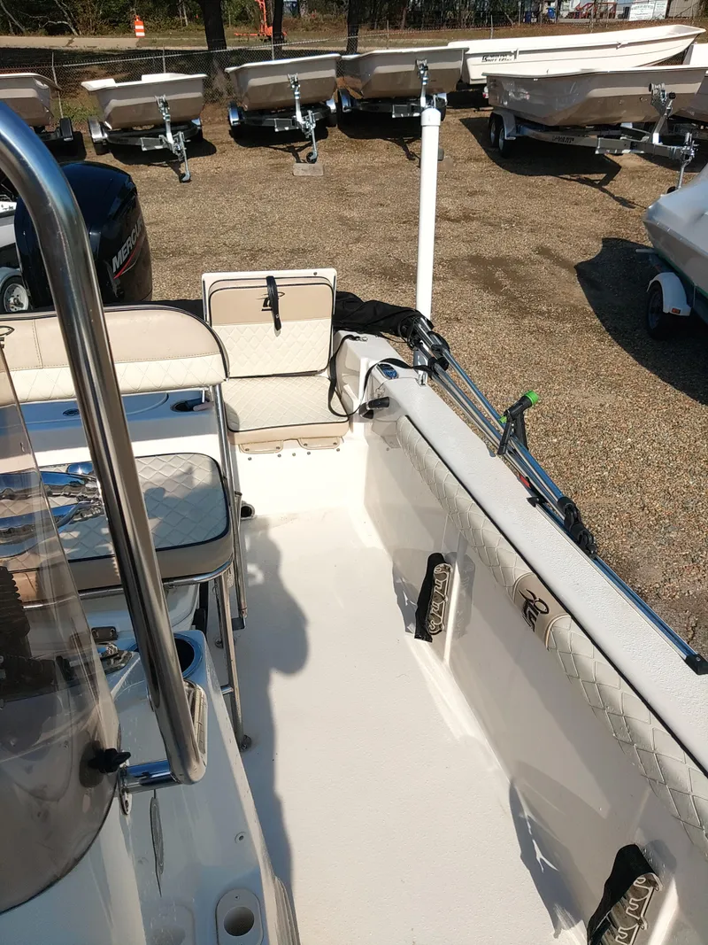 Slide: The Image of 2022 Carolina Skiff 19 LS boat interior with seating and storage, displayed outdoors. - 8