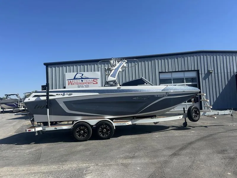 Slide: The Image of 2019 Tigé ZX5 boat on trailer outside West Texas Watersports building. - 0