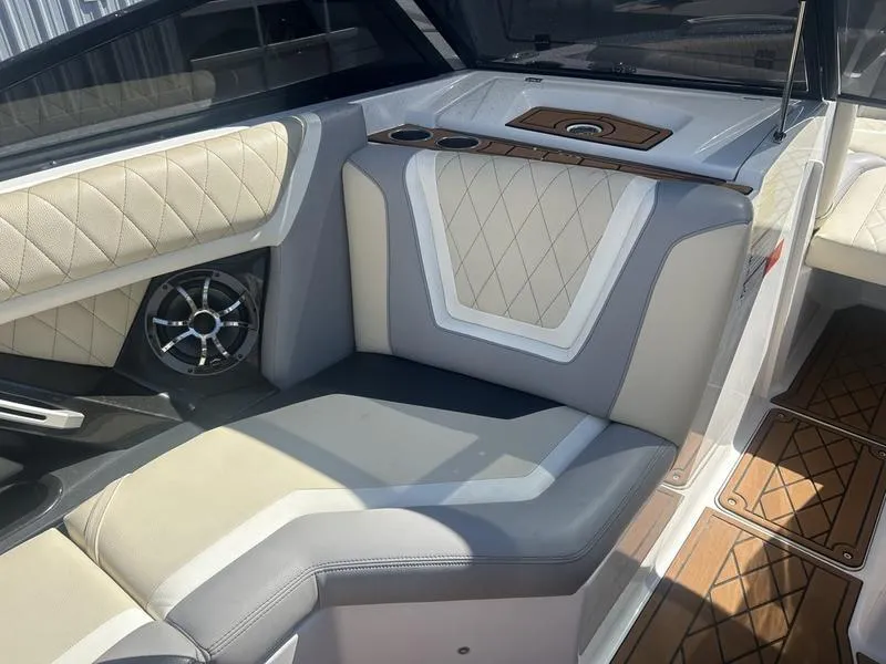 Slide: The Image of 2019 Tigé ZX5 boat interior with beige and gray seating, diamond stitching, and wood accents. - 3