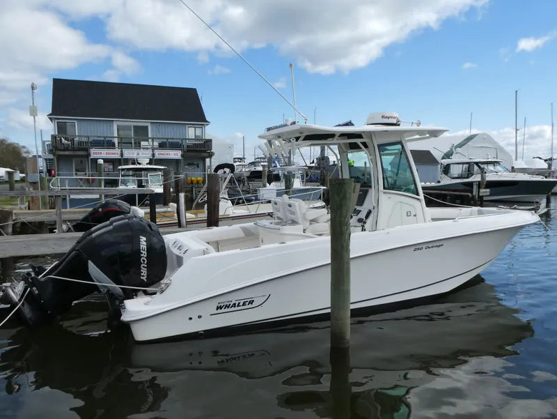 Slide: The Image of 2016 Boston Whaler 250 Outrage boat docked at marina with Mercury engine. - 1