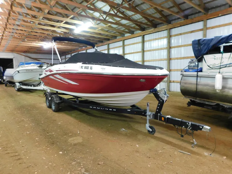The Image of 2020 Bayliner VR 6 boat in storage, red hull, covered, on trailer. - 1