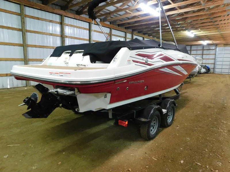 Slide: The Image of 2020 Bayliner VR 6 boat in storage, red and white design, on a trailer. - 3