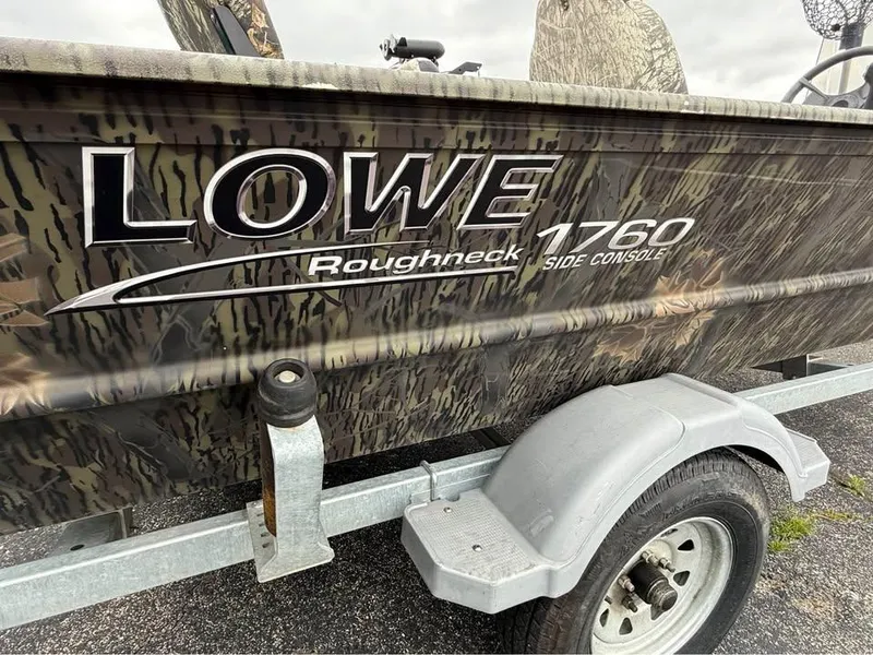 Slide: The Image of 2018 Lowe Roughneck 1760SC boat on trailer, camo design, side console visible. - 11