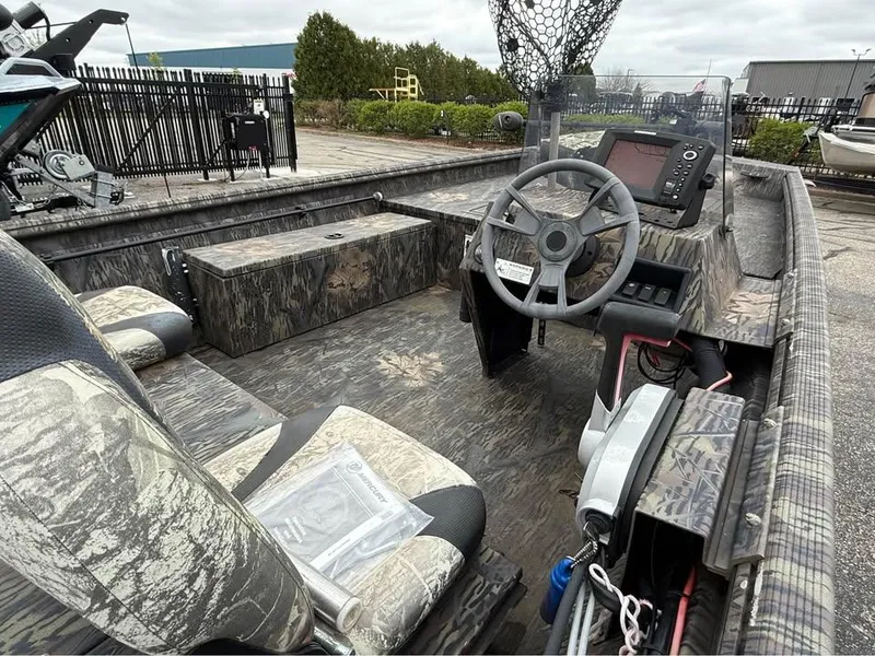 Slide: The Image of 2018 Lowe Roughneck 1760SC boat interior with camo seats, steering wheel, and control panel. - 5