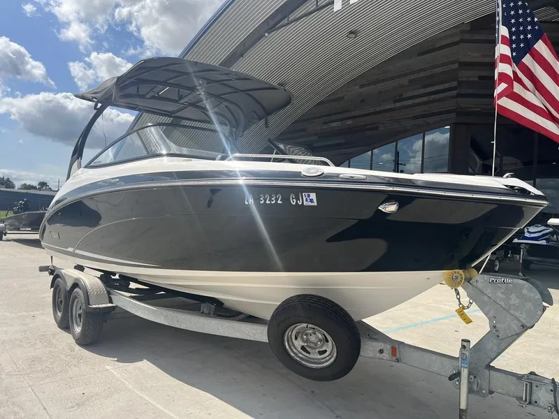 Slide: The Image of 2018 Yamaha 242 Limited S E-Series boat on trailer, outdoors with American flag. - 3