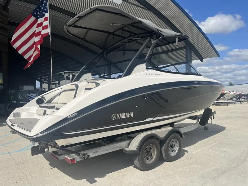 Slide: The Image of 2018 Yamaha Boats 242 Limited S E-Series on trailer, under a canopy, with American flag. - 8