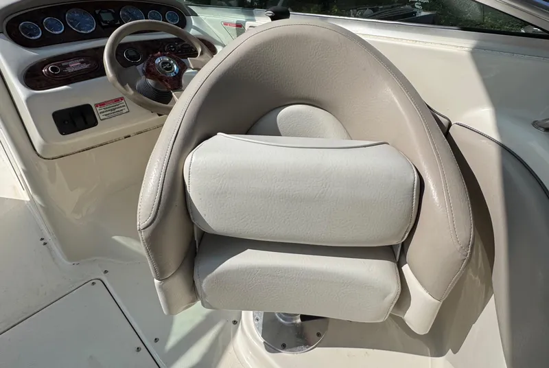 Slide: The Image of 2003 Sea Ray 240 Sundeck helm with beige captain's chair and dashboard controls. - 10