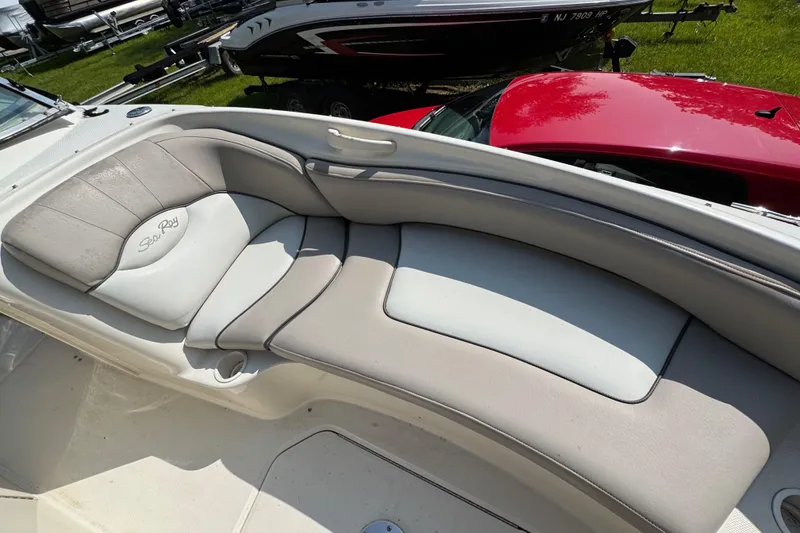 Slide: The Image of 2003 Sea Ray 240 Sundeck interior seating with beige and white upholstery. - 14
