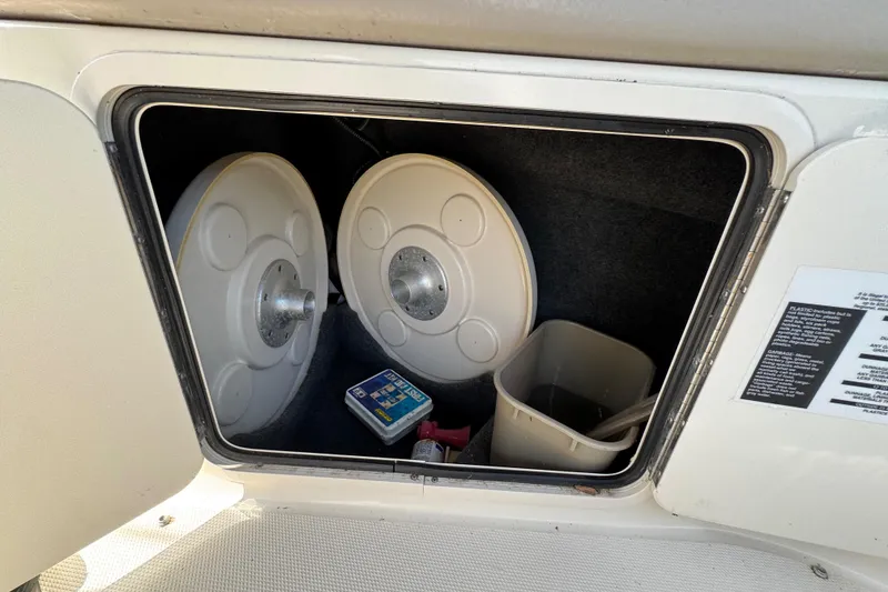 Slide: The Image of Storage compartment of a 2003 Sea Ray 240 Sundeck with equipment and accessories. - 3