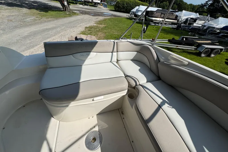 Slide: The Image of 2003 Sea Ray 240 Sundeck interior seating with beige upholstery and cup holders. - 5