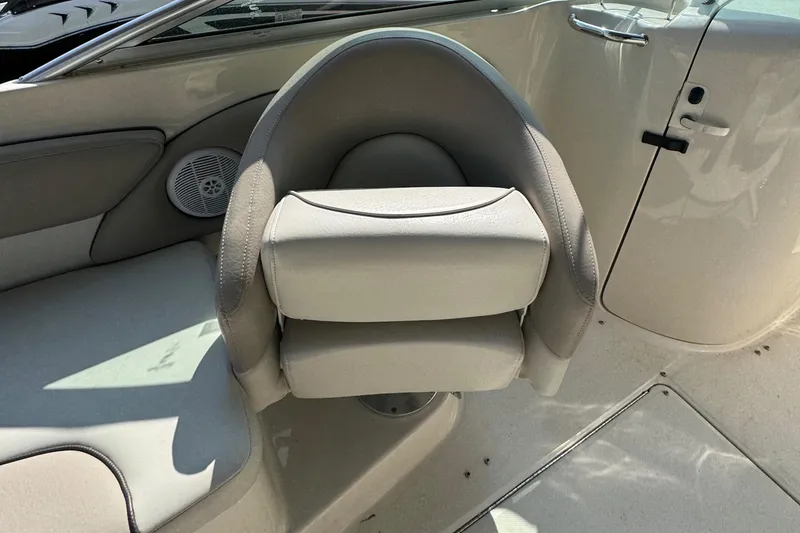 Slide: The Image of 2003 Sea Ray 240 Sundeck interior with beige seating and speaker detail. - 7