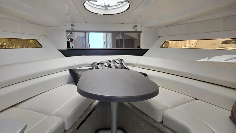 Slide: The Image of 2022 Monterey 295SY boat interior with sleek seating and modern table design. - 14