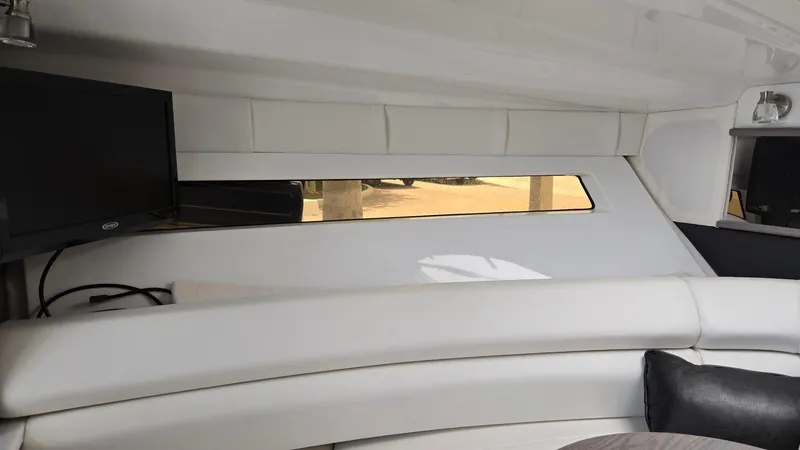 Slide: The Image of Interior of 2022 Monterey 295SY boat with white seating and a mounted TV. - 15