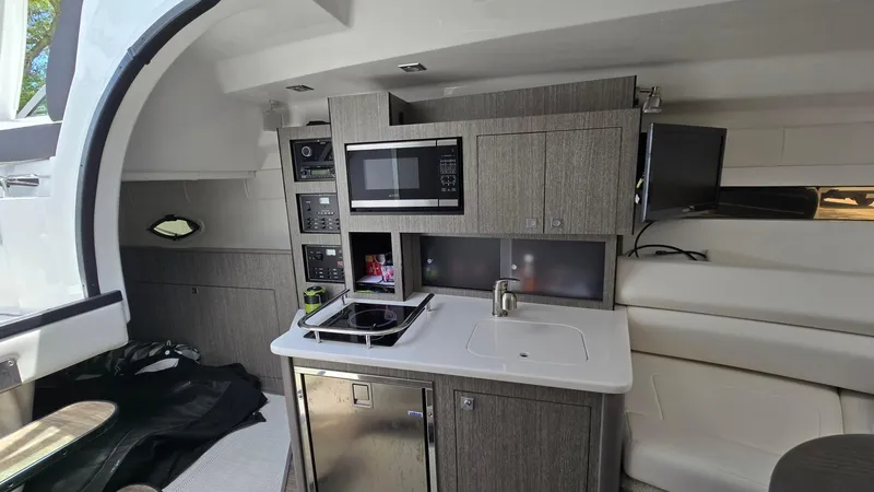 Slide: The Image of 2022 Monterey 295SY yacht interior with modern kitchenette and sleek cabinetry. - 16