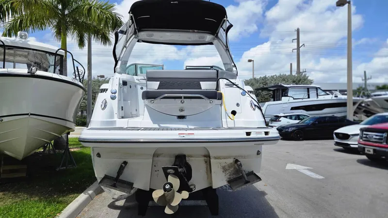 Slide: The Image of 2022 Monterey 295SY boat, rear view, parked outdoors under a sunny sky. - 3
