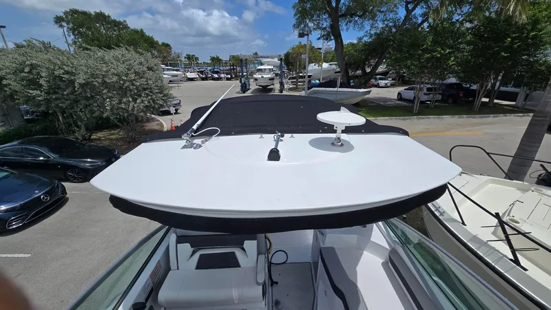 Slide: The Image of 2022 Monterey 295SY boat docked, featuring sleek design and modern amenities under a clear sky. - 4