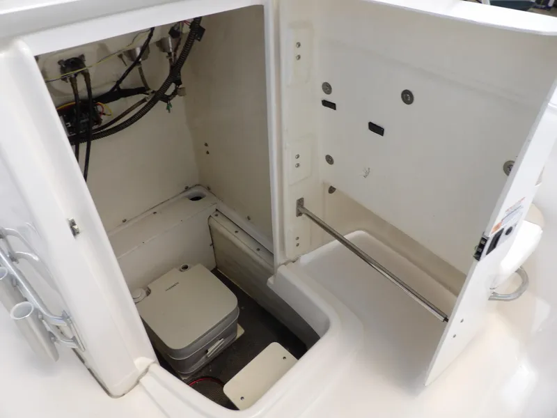 Slide: The Image of 2020 Robalo R180 boat interior storage compartment with portable toilet and wiring. - 12